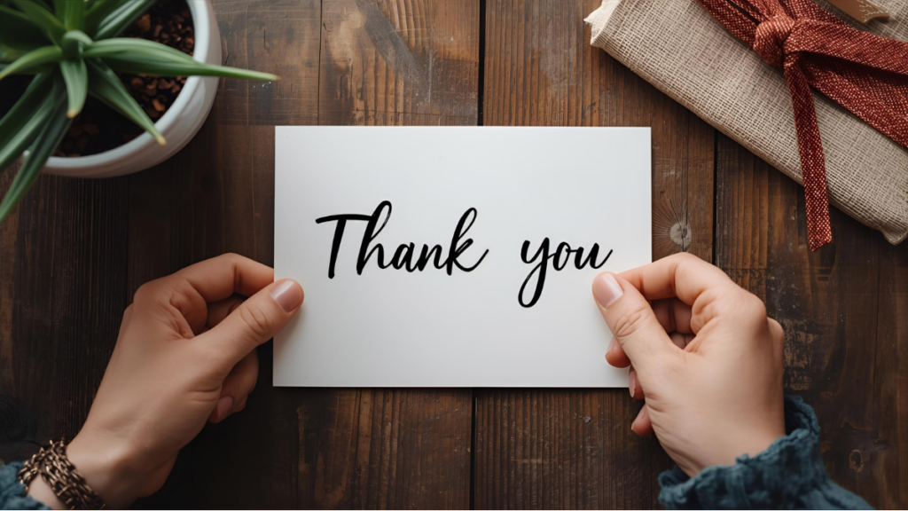 A thank you card displayed on a wooden table, held by hands, highlighting gratitude in nonprofit work.